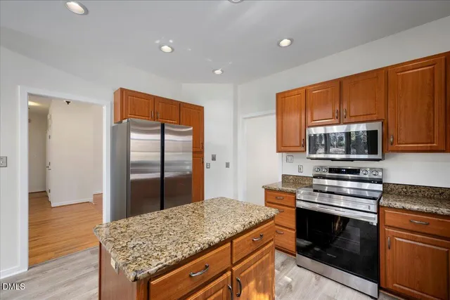 a kitchen with stainless steel appliances granite countertop a stove microwave and refrigerator
