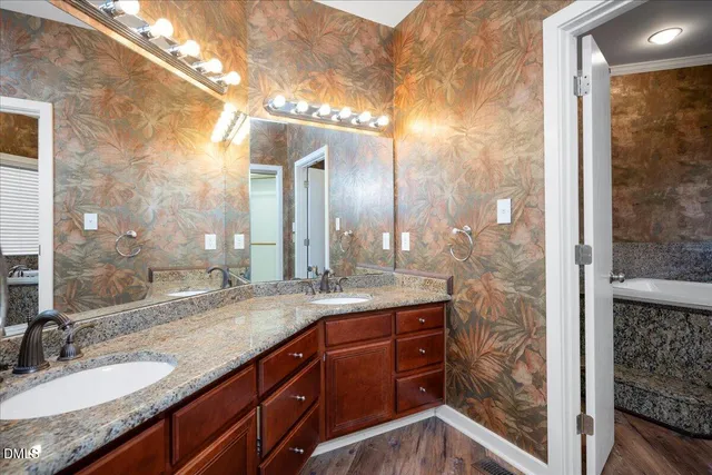 a bathroom with a granite countertop sink a mirror and a shower