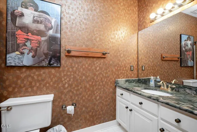 a bathroom with a granite countertop sink mirror vanity and toilet