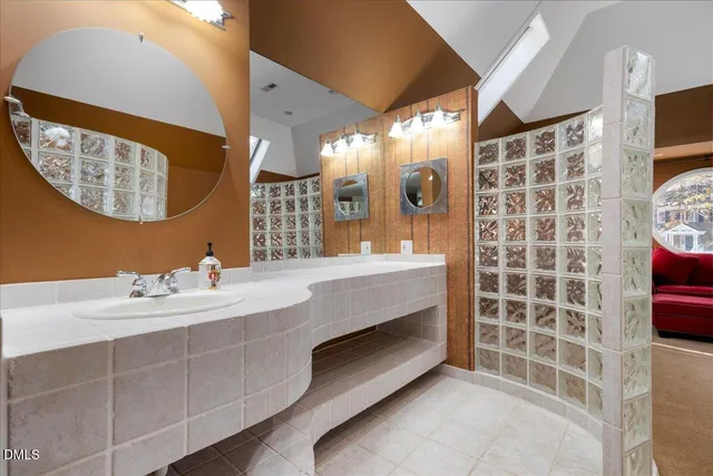 a bathroom with a double vanity sink mirror and bathtub