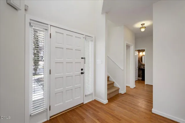 an entryway with a room and wooden floor