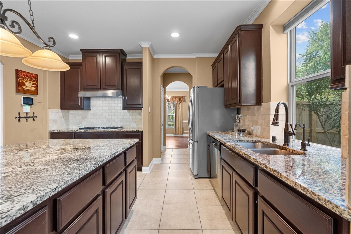 1358 Porta Rosa Lane League City, TX 77573 - Photo 7 of 48 An eat-in island kitchen showcases granite countertops, stainless steel appliances, and 42" cabinetry finished with crown molding.