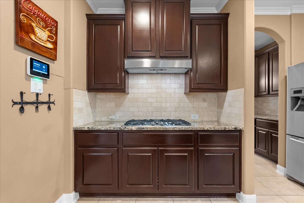 1358 Porta Rosa Lane League City, TX 77573 - Photo 9 of 48 An eat-in island kitchen showcases granite countertops, stainless steel appliances, and 42" cabinetry finished with crown molding.