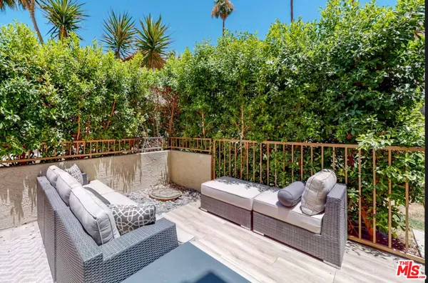 a roof deck with couches and wooden fence