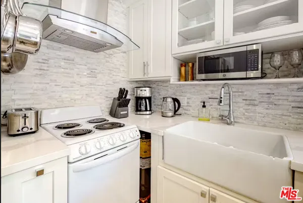 a kitchen with stainless steel appliances a sink a stove and a refrigerator with wooden floor