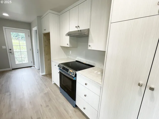 a kitchen with granite countertop a stove and a refrigerator