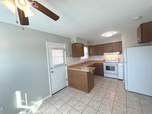 a kitchen with stainless steel appliances granite countertop a refrigerator and a stove