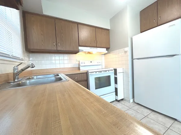 a kitchen with a refrigerator sink and cabinets