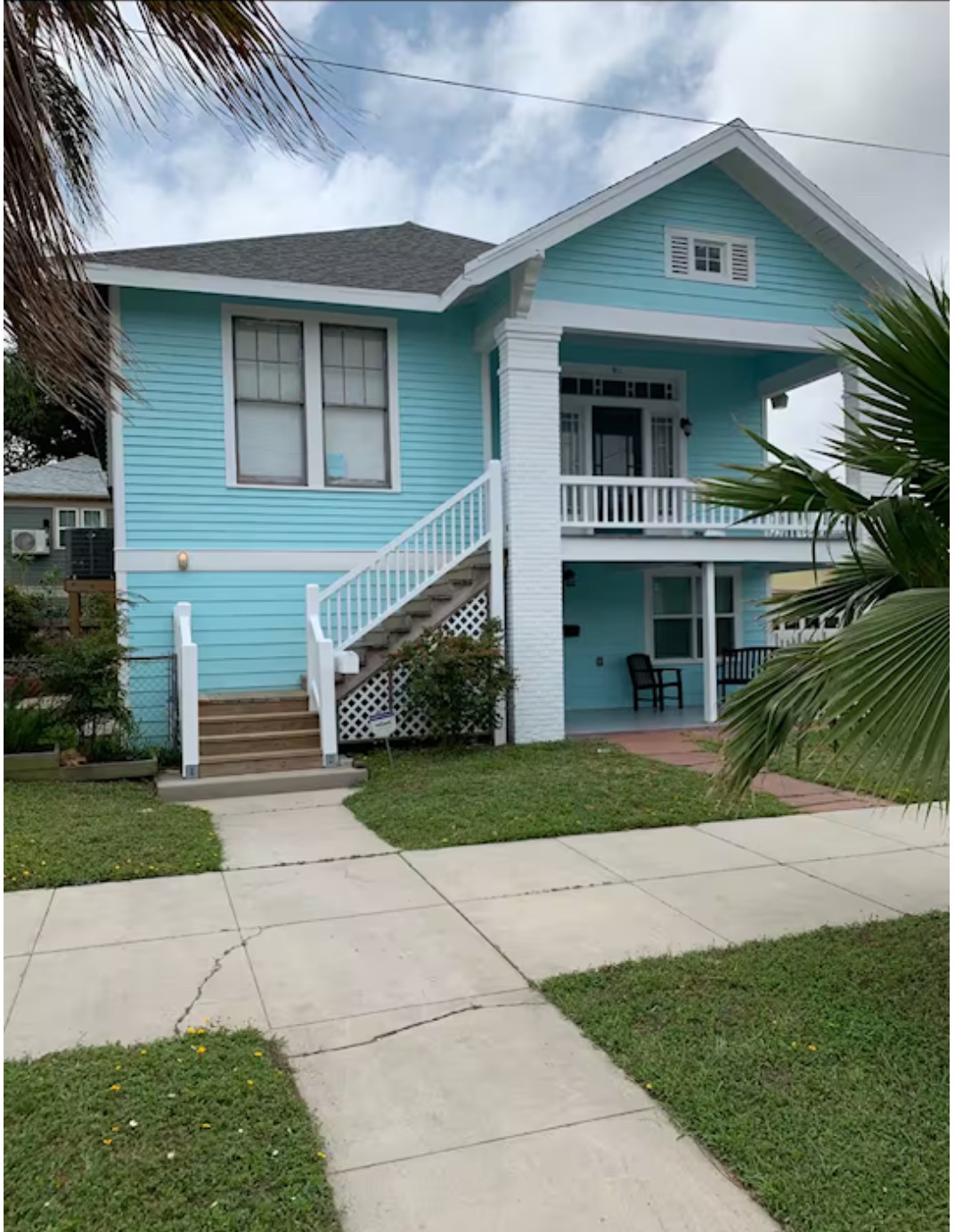 911 11th Street, Unit 2 Galveston, TX 77550 - Photo 2 of 20 a front view of a house with a yard and potted plants
