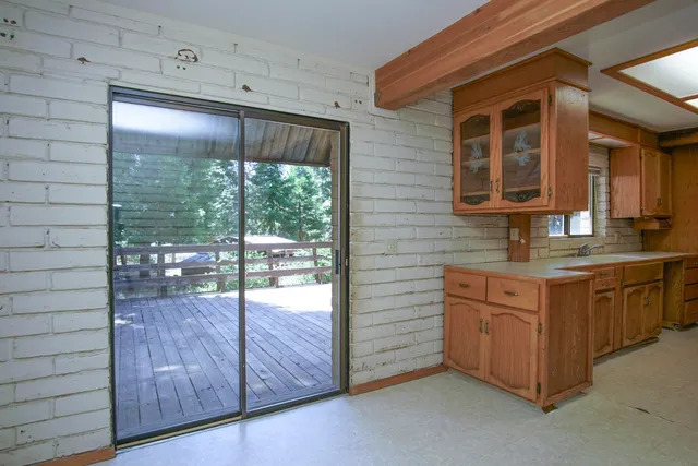 a kitchen with granite countertop a sink stainless steel appliances wooden floor and a window