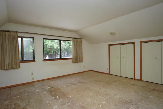 a view of an empty room with window and cabinet