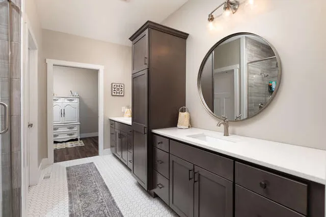 a en suite bathroom with a granite countertop sink and a mirror