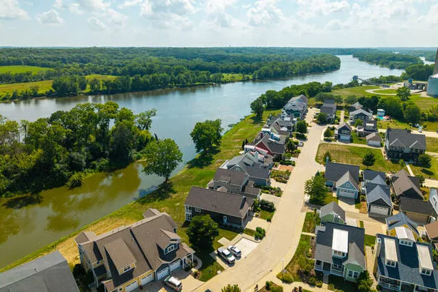 an aerial view of residential houses with outdoor space and lake view