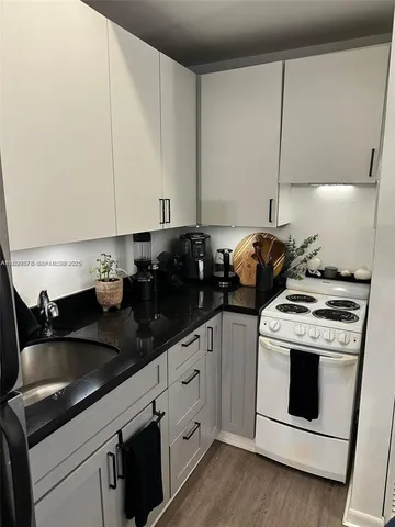 a kitchen with granite countertop white cabinets and white appliances