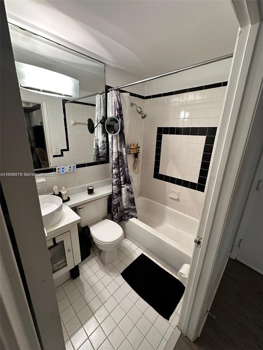 1244 Pennsylvania Avenue, Unit 103 Miami Beach, FL 33139 - Photo 5 of 11 a bathroom with a toilet sink and mirror