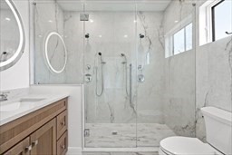 8 Orchard Road, Unit B Gloucester, MA 01930 - Photo 6 of 8 a bathroom with a granite countertop toilet a sink a mirror and shower