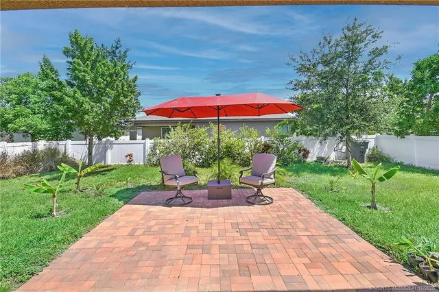 a view of a patio with a table and chairs under an umbrella