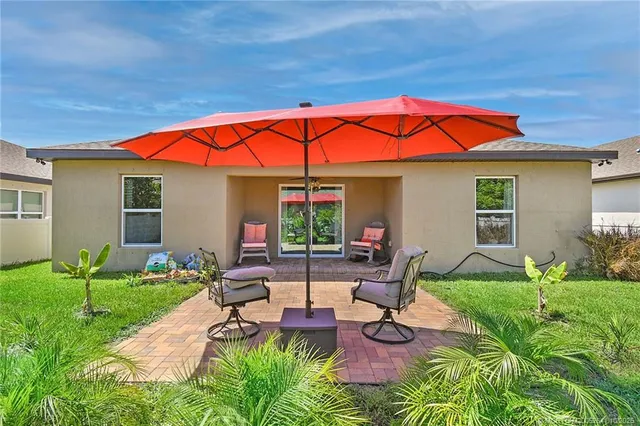 a view of a backyard with table and chairs under an umbrella