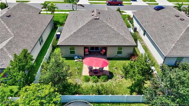 a view of a house with table and chairs under an umbrella