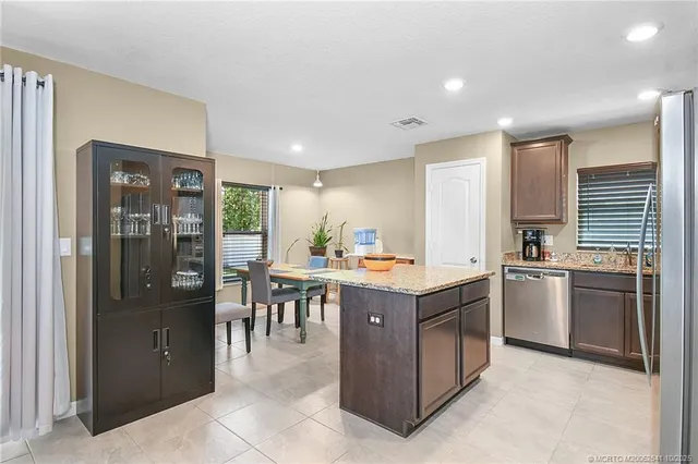 a kitchen that has a lot of cabinets in it and stainless steel appliances