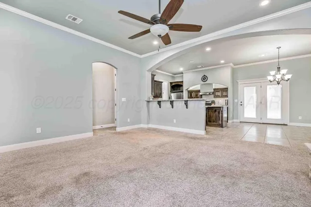 a view of a livingroom with a ceiling fan a kitchen space a sink and a window