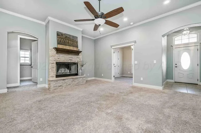 an empty room with fan and a fireplace