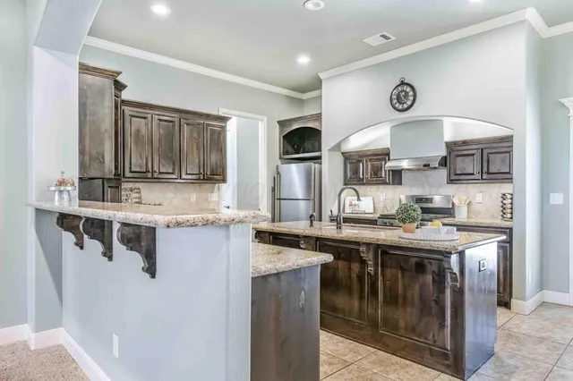 a kitchen with stainless steel appliances granite countertop a sink and stove top oven
