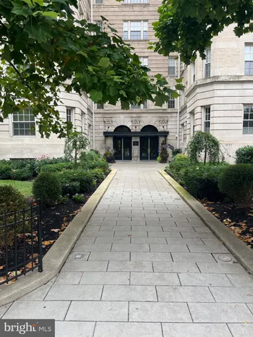 a view of house and garden with large trees