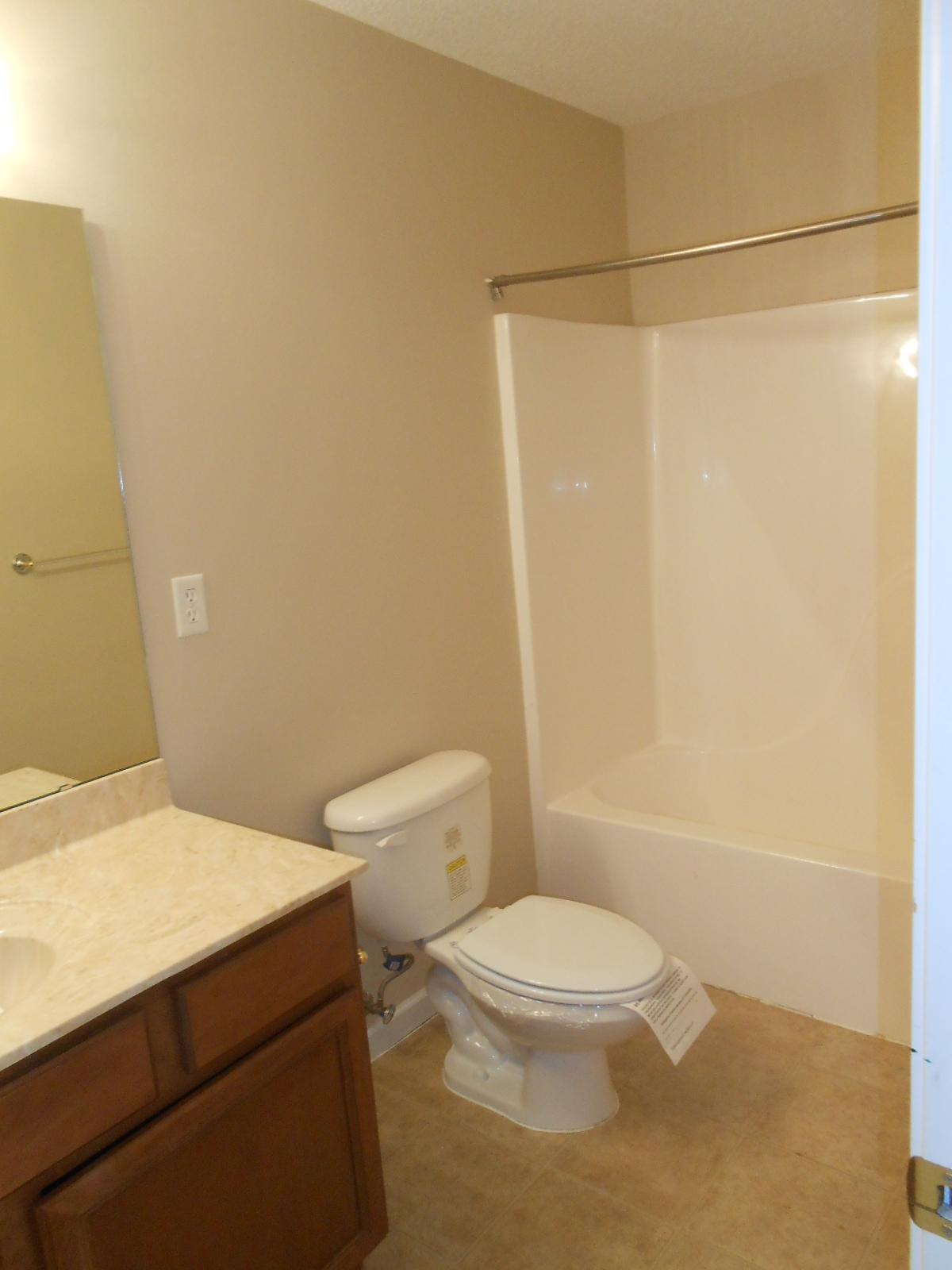 145 Laurel Lane DeFuniak Springs, FL 32433 - Photo 11 of 13 a white toilet sitting next to a shower curtain