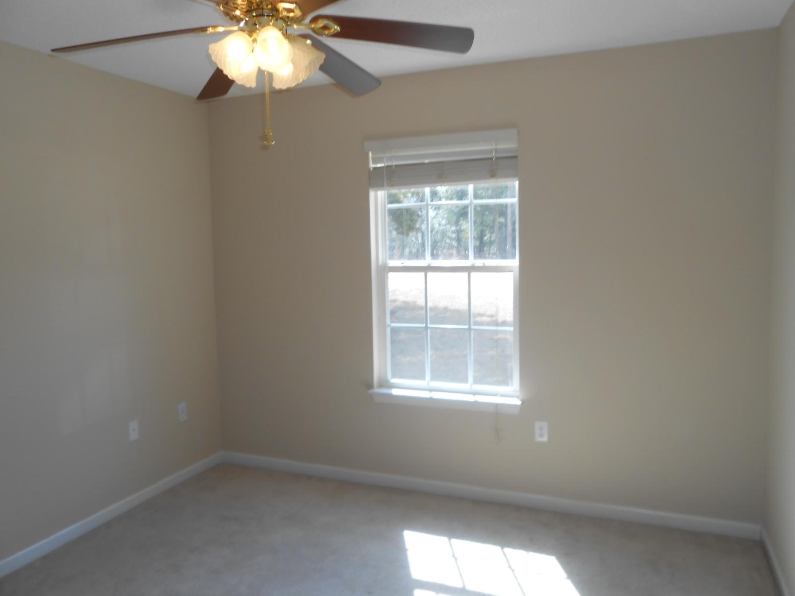 145 Laurel Lane DeFuniak Springs, FL 32433 - Photo 5 of 13 an empty room with window and chandelier fan