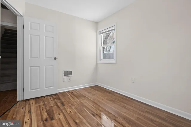 a view of empty room with wooden floor