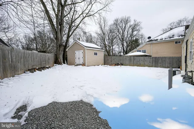 a view of a white house with a yard covered in snow