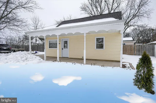 a view of a house with a yard covered in snow