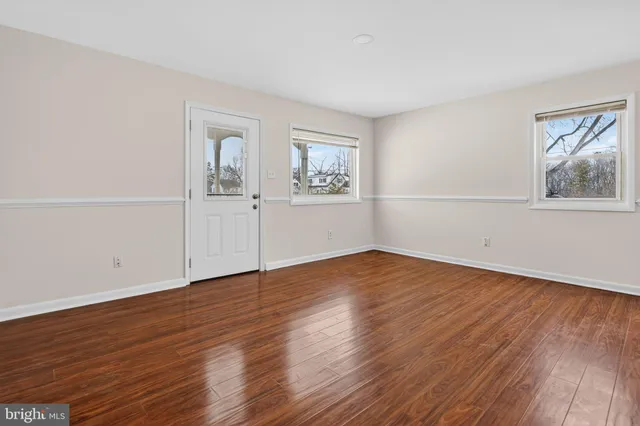 a view of empty room with wooden floor and window