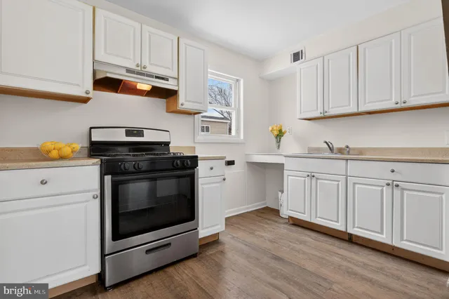 a kitchen with white cabinets and appliances