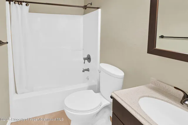 a white toilet sitting next to a bath tub