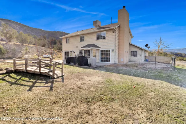 a view of a white house with a yard