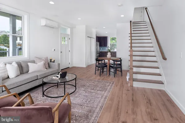 a living room with furniture a wooden floor and next to a window