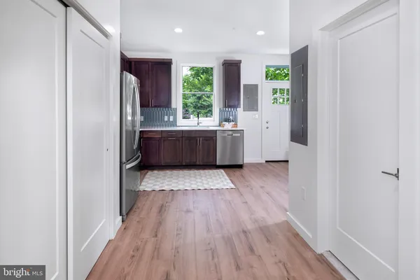 a kitchen with stainless steel appliances a refrigerator and a wooden floor
