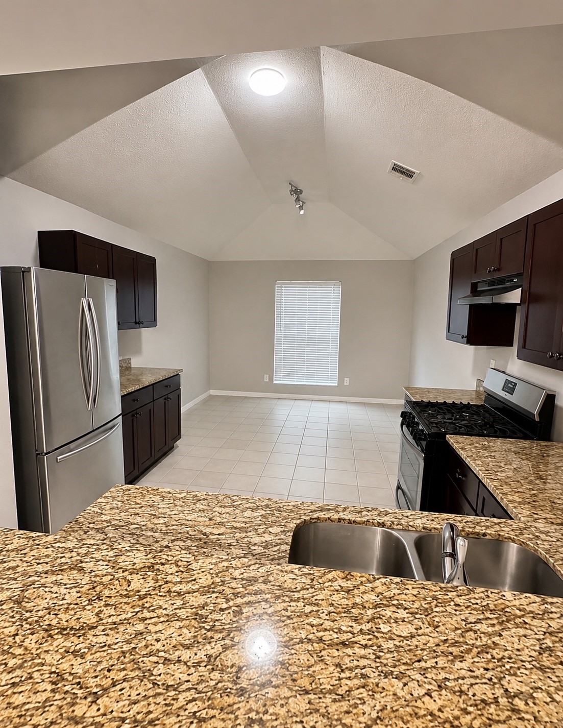 22707 Bridgewater Drive Spring, TX 77373 - Photo 4 of 11 a kitchen with granite countertop a stove and refrigerator