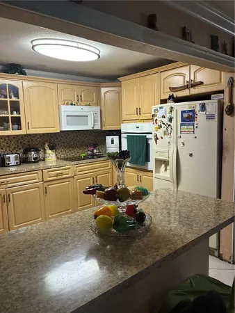 a kitchen with stainless steel appliances kitchen island granite countertop a sink and cabinets