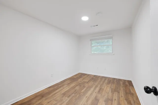 a view of a room with wooden floor and white walls