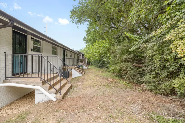a view of wooden house with a patio and a yard