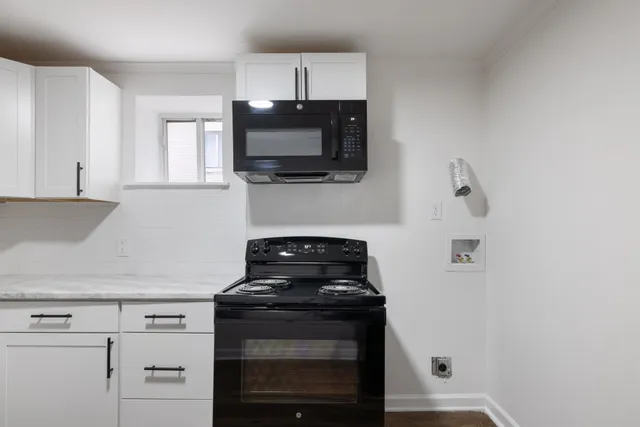a kitchen with stainless steel appliances a stove microwave and sink
