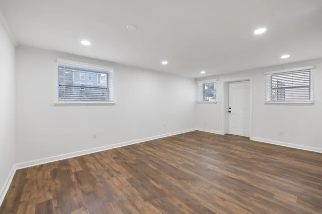 a view of empty room with wooden floor