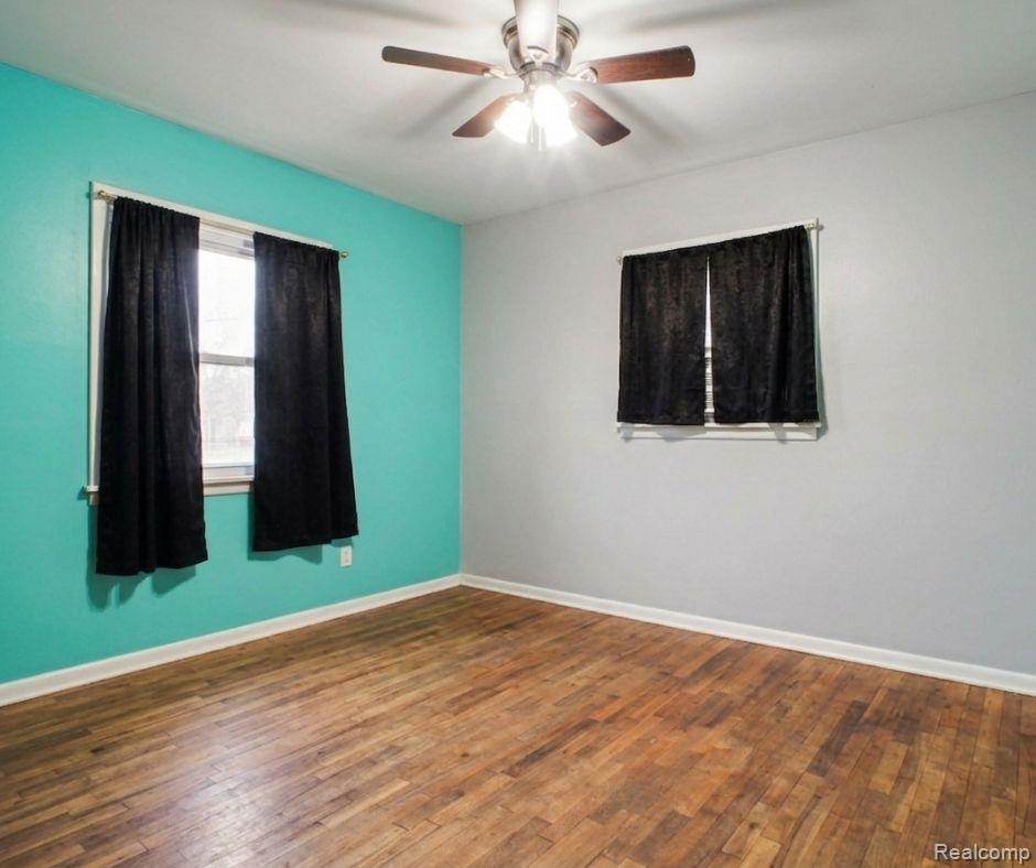 5082 North Center Road Flint, MI 48506 - Photo 4 of 21 Wood-finish flooring, ceiling fan with light fixture, and two windows