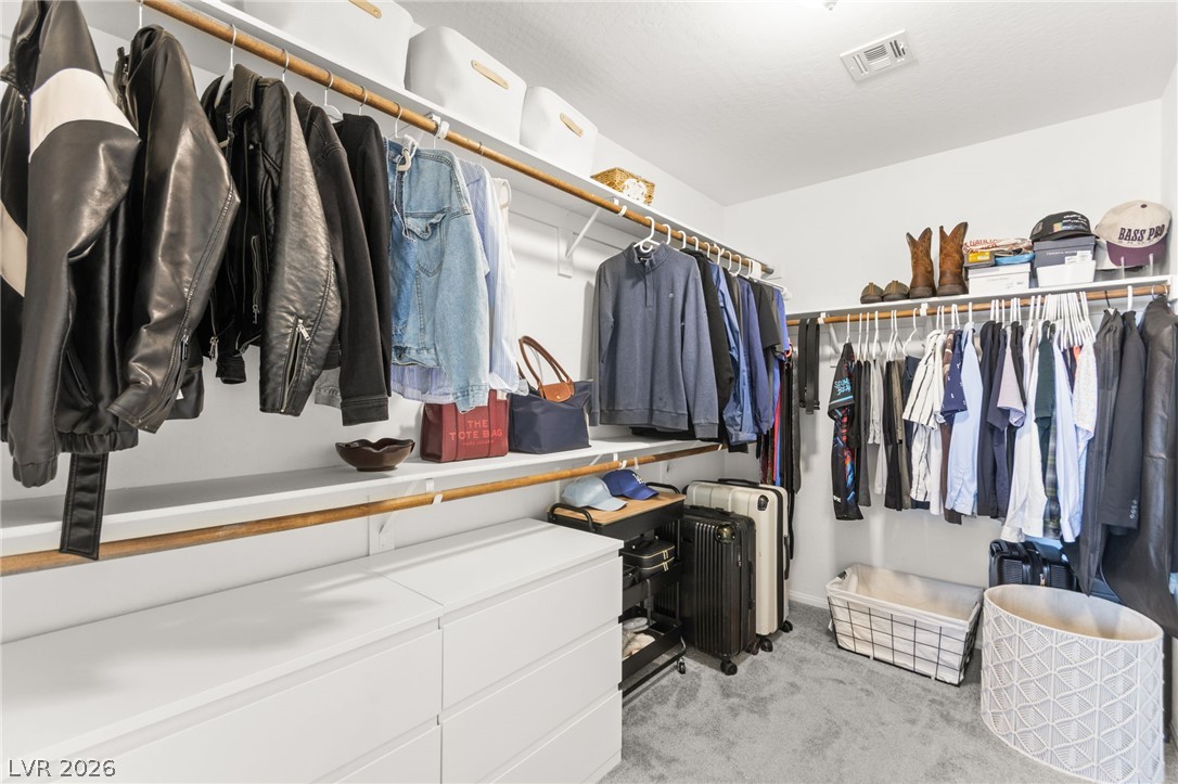 6435 Point Isabel Way Las Vegas, NV 89122 - Photo 31 of 57 Well-appointed walk-in closet with ample storage, integrated shelving, and carpeted flooring.