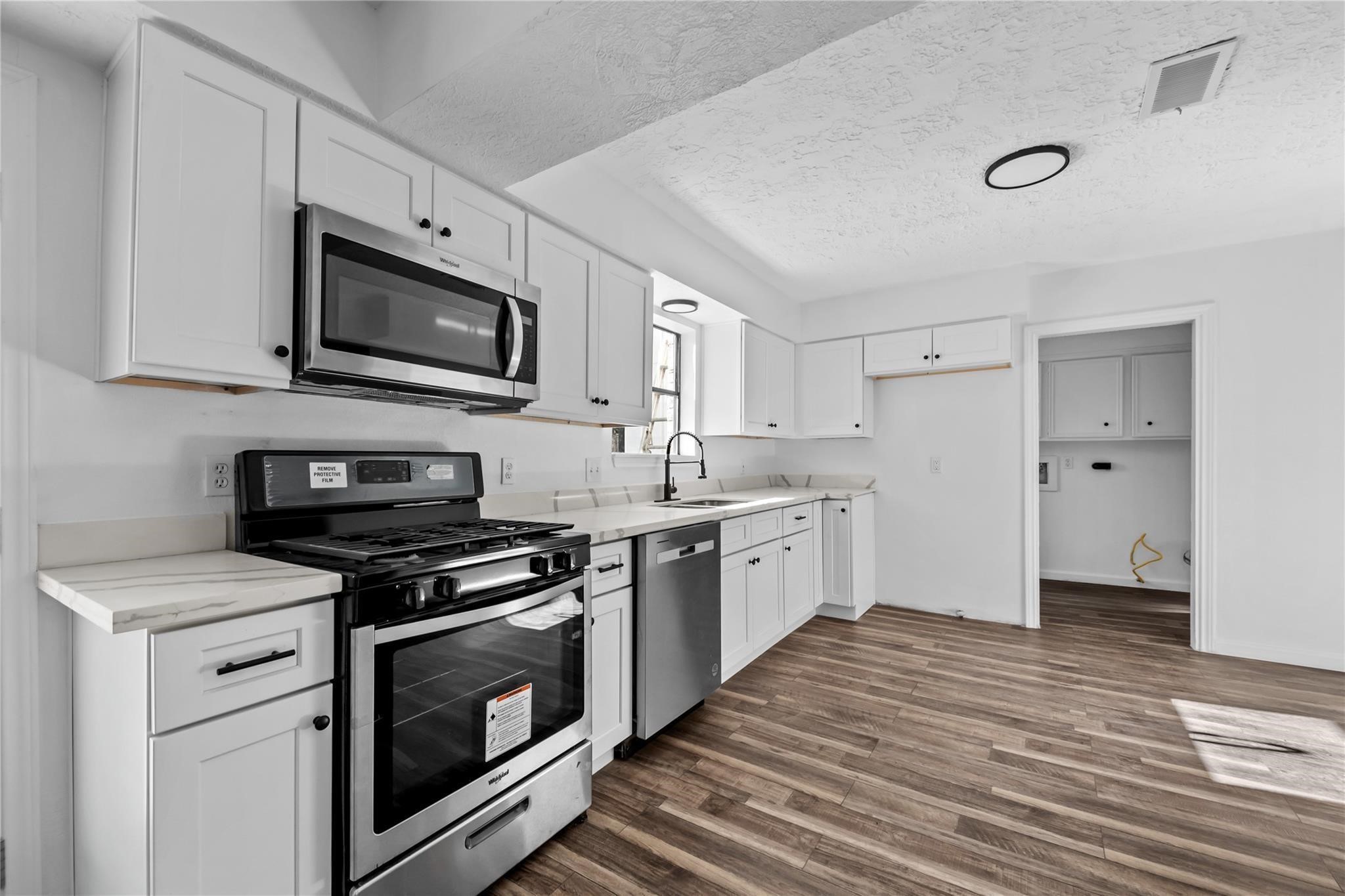 6611 Falling Waters Drive Spring, TX 77379 - Photo 13 of 16 a kitchen with stainless steel appliances a stove microwave and sink