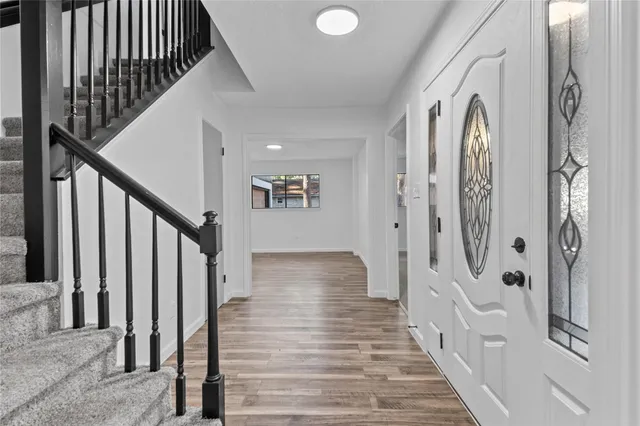 a view of a hallway with wooden floor and staircase