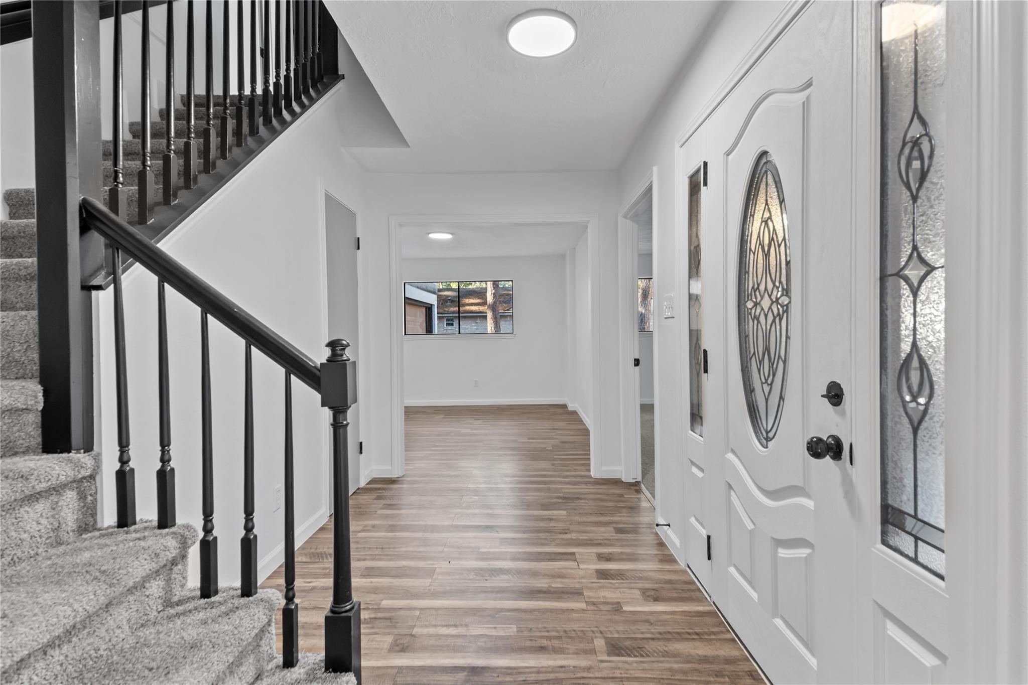 6611 Falling Waters Drive Spring, TX 77379 - Photo 10 of 16 a view of a hallway with wooden floor and staircase
